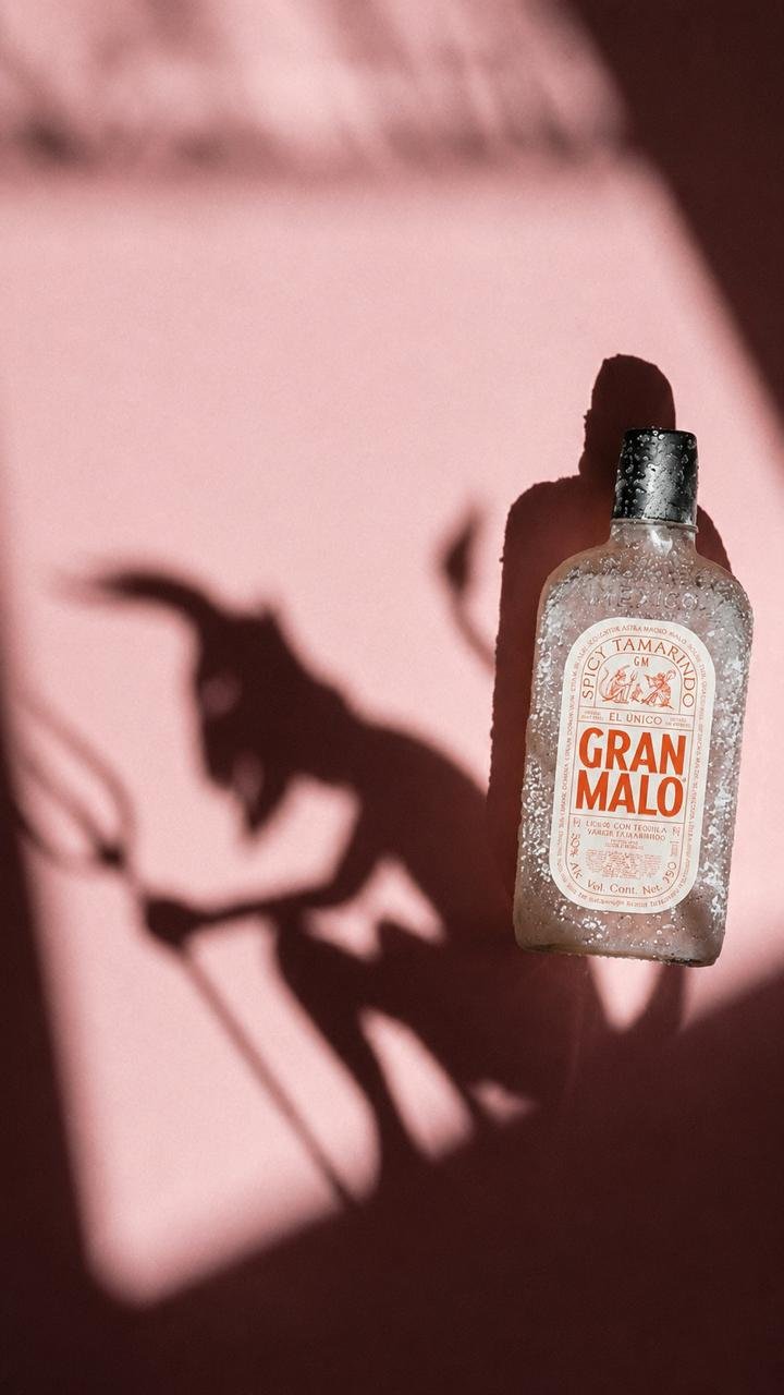 Botella de Gran Malo en una composición editorial rosa