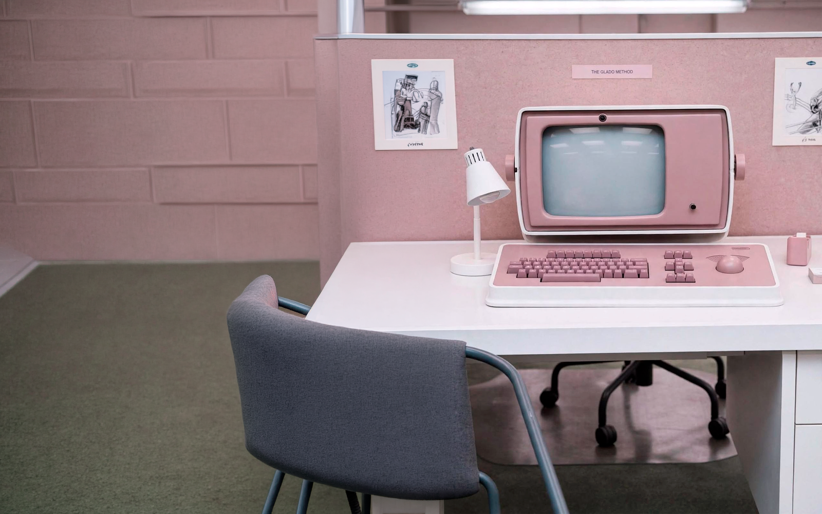 Estación creativa rosa con computadora retro y bocetos de The Glado Method